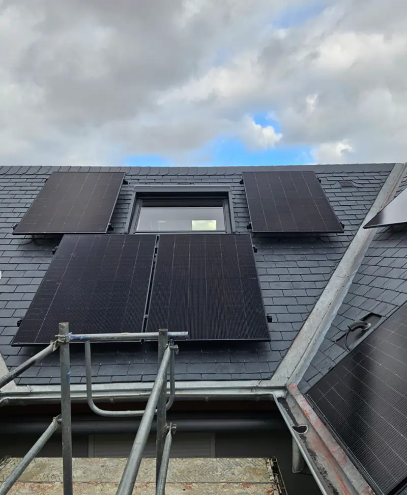 Panneaux solaires installés de part et d'autre d'une fenêtre de toit